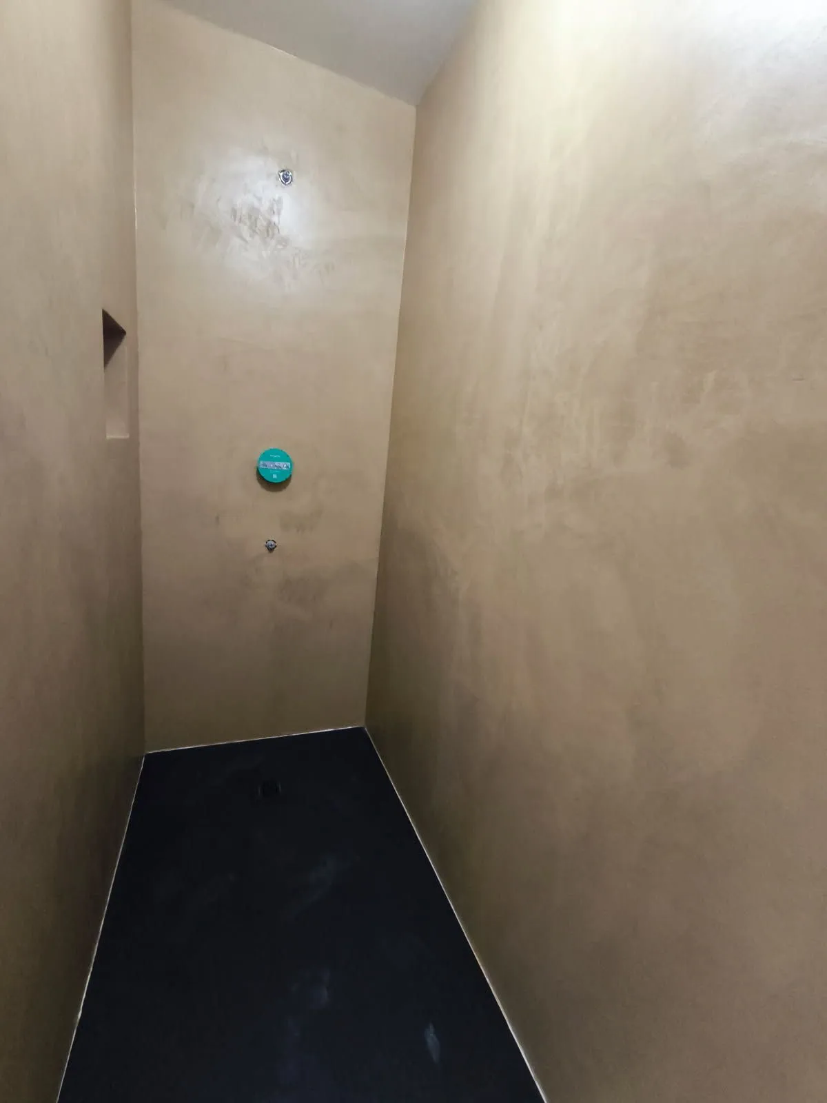 Douche à l'italienne en béton ciré sable avec receveur noir sans joint