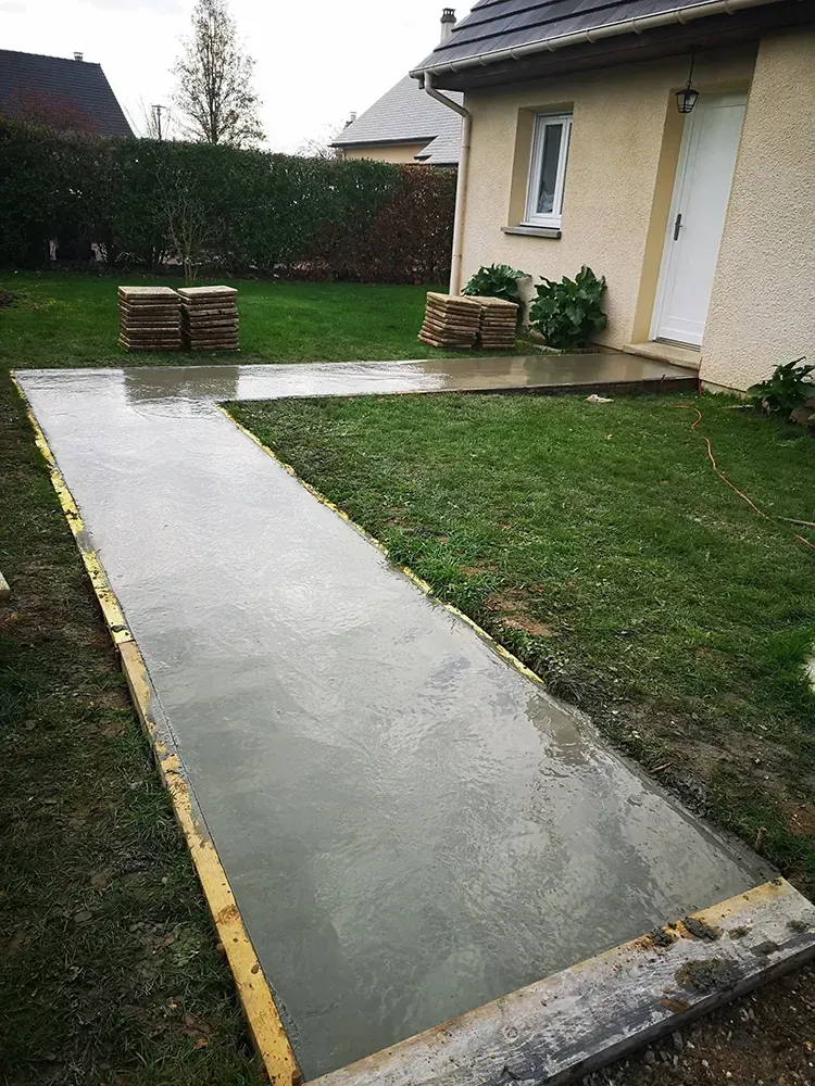 Allée et terrasse en béton brut dans un jardin normand