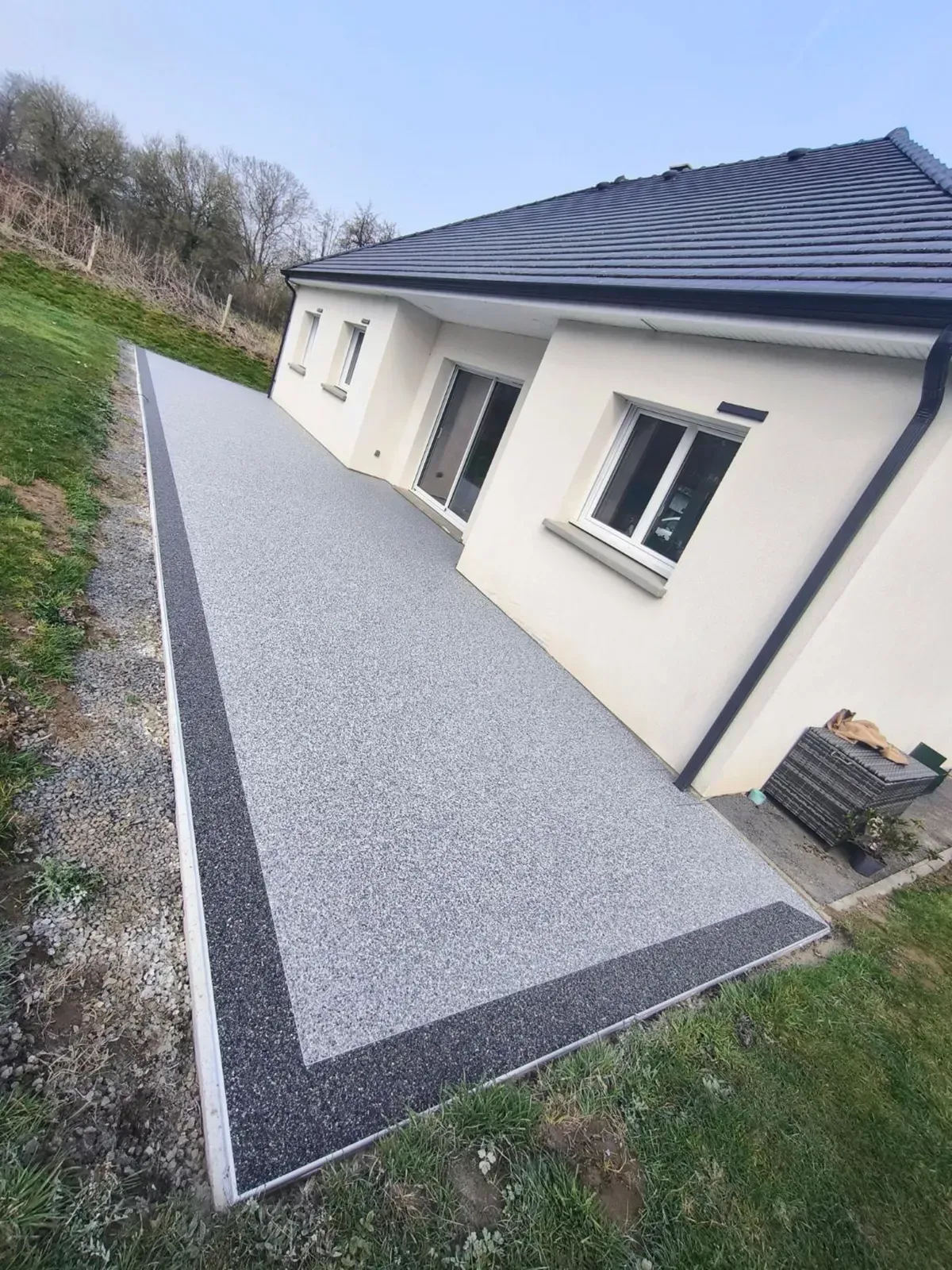 Terrasse en moquette de pierre grise avec bordure anthracite en Seine-Maritime