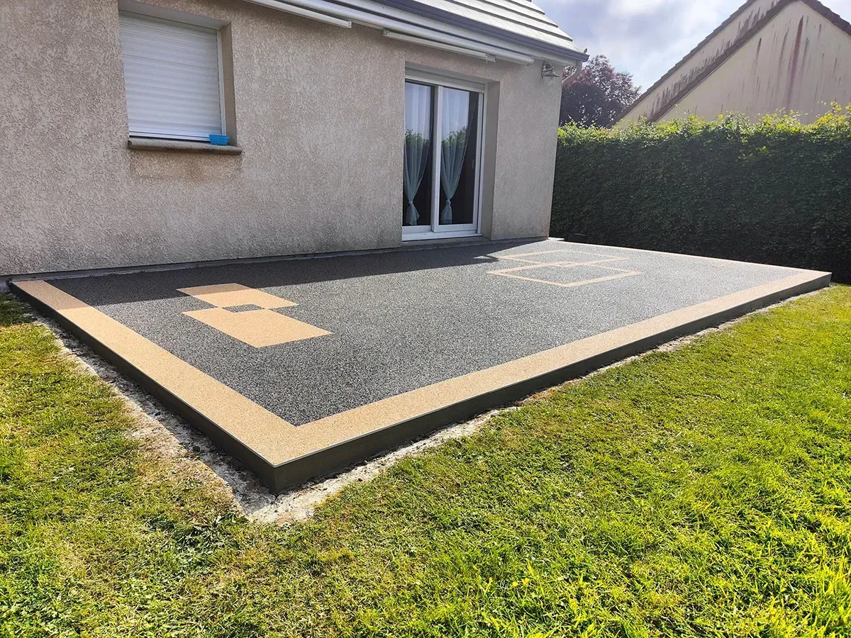 Terrasse en moquette de pierre grise encadrée d'une bordure beige près d'Yvetot