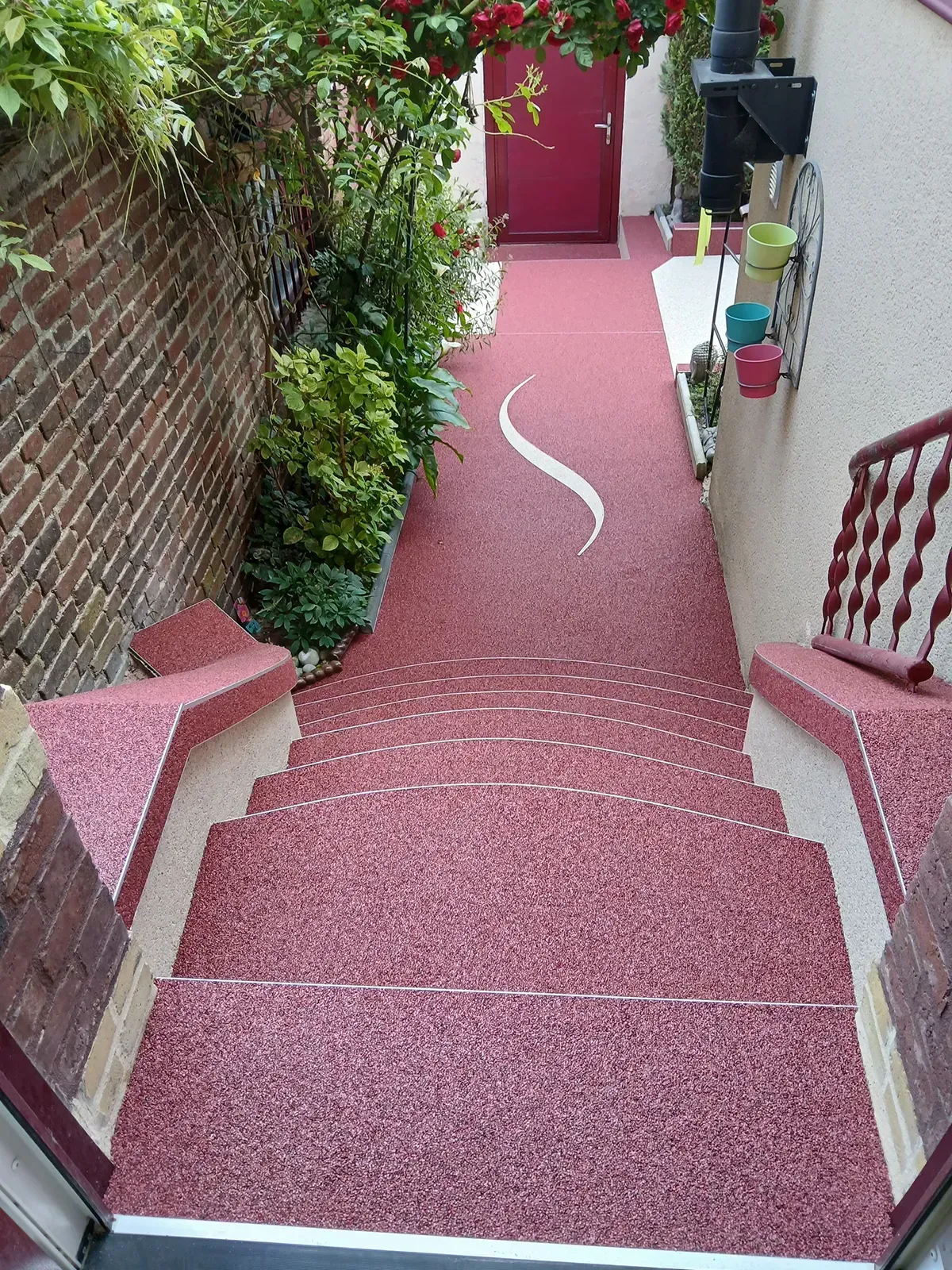 Escalier extérieur et allée en moquette de pierre rouge à l'entrée d'une maison