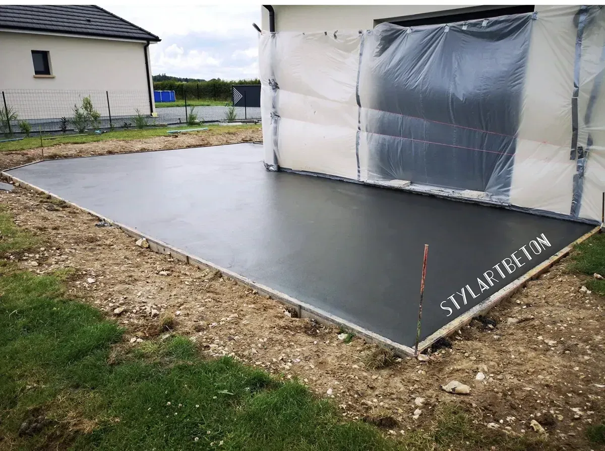 Terrasse en béton brut lissé en cours de finition en Seine-Maritime