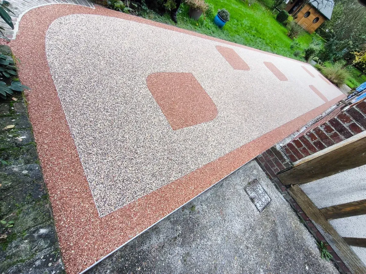 Allée en moquette de pierre beige et terracotta devant une maison normande