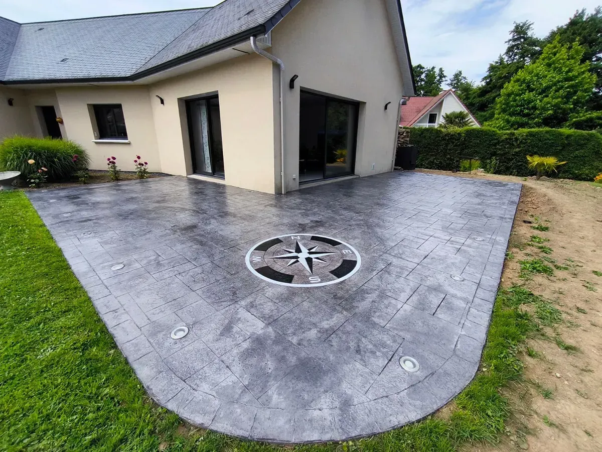 Terrasse en béton imprimé effet pierre avec rose des vents réalisée en Normandie
