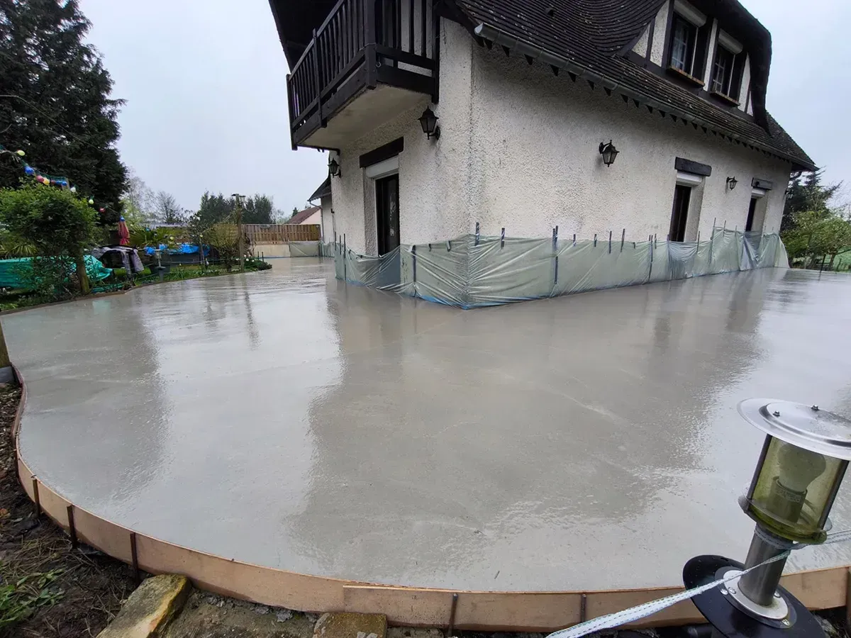 Cour en béton réalisée par Styl Art Béton autour d'une maison normande